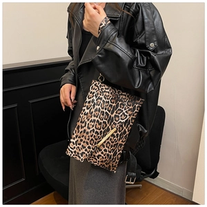 Detail of leopard print shoulder bag with gold metal trim and textured finish