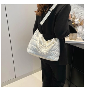Détail du sac bandoulière matelassé blanc avec large sangle et fini brillant
