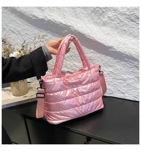 Detailed shot of pink quilted puffer tote bag with glossy finish and wide strap