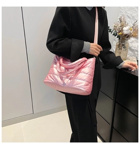 Modèle portant un sac cabas en coton spatial matelassé rose avec finition brillante