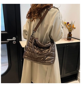 Détail d'un sac en coton matelassé brillant avec une large bandoulière réglable