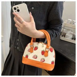 Détail du sac coquillage à imprimé fraises avec anses orange et zips dorés