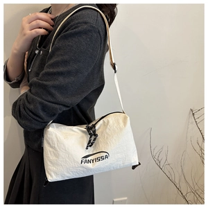 Vue détaillée du sac bandoulière en nylon blanc avec cordon noir et logo texte FANYISSA
