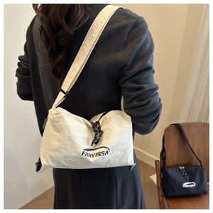 Détail du sac bandoulière en nylon avec logo et fermetures éclair à nœuds décoratifs