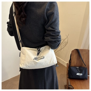 Détail du sac bandoulière en nylon avec cordons de serrage et logo FANYISSA gravé