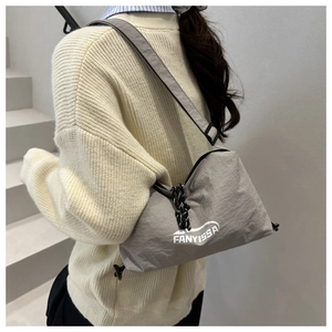 Detail of adjustable strap and nylon texture of the grey sporty crossbody bag on model
