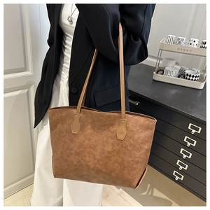 Detailed close-up of a large caramel vintage tote bag in synthetic leather texture