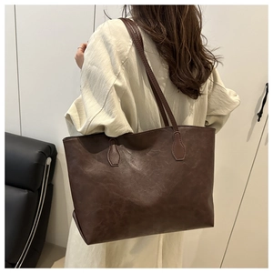 Detail of dark brown vintage faux leather tote bag with reinforced shoulder straps