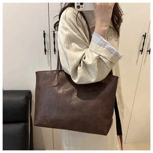 Detail view of large coffee brown retro tote bag shown on model with minimalist design