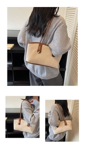 Detail of minimalist tote bag showing beige canvas texture and brown leather knotted side strap