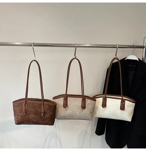 Three colors of tote bags with knot detail hanging on a rack for autumn commute