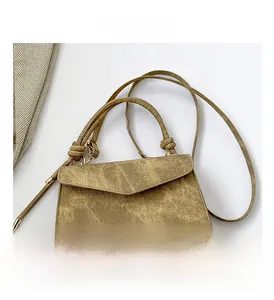 Detail view of mustard yellow vintage crossbody bag with flap and knot strap design