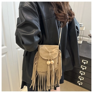 Détail du mini sac bandoulière en daim kaki clair avec pompons et perles en bois