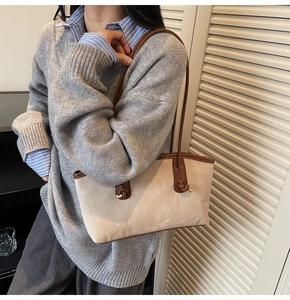 Detail of the unique knotted leather handle and soft suede texture on the beige tote bag