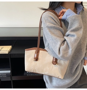 Detail view of beige suede tote bag with knotted coffee leather strap and fashion text
