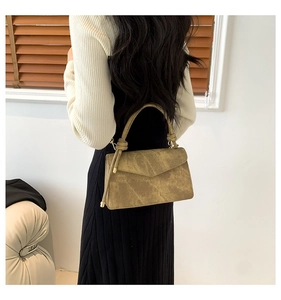 Olive brown suede handbag with knotted handle and gold metal hardware shown on model