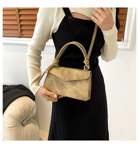 Khaki crossbody bag featuring a twisted handle and flap closure for daily wear