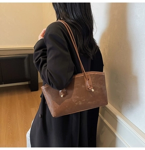 Detail of vintage brown textured leather underarm bag with decorative metal buckle