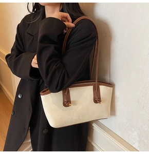 Detail of minimalist tote bag showing suede texture, brown leather straps and knot accents