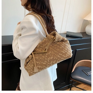 Detail of camel shearling shoulder bag with leather straps on a beige blazer