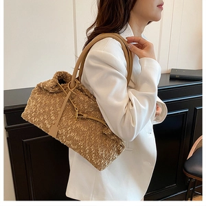 Detail of khaki fleece tote bag with brown leather shoulder straps and metal buckle