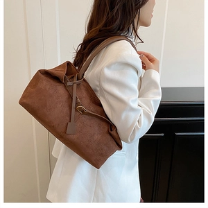 Detail of vintage brown suede tote bag with leather strap shown in a chic room setting