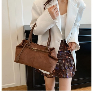 Detail view of the brown suede tote bag with slim shoulder straps and metal buckle