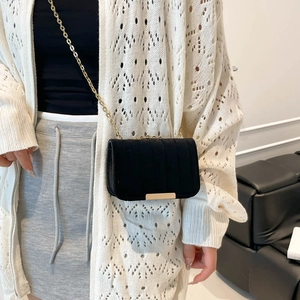 Minimalist black velvet crossbody bag with vertical texture and gold chain strap