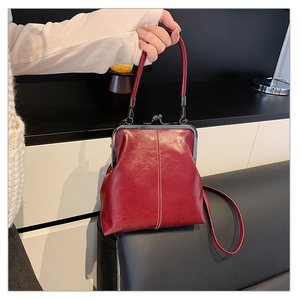 Detail of vintage red doctor bag in wax leather with metal clasp and white stitching