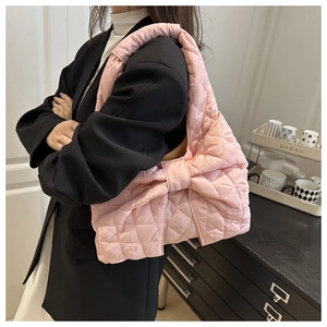 Detail of pink quilted tote bag with oversized bow design and padded puffer texture