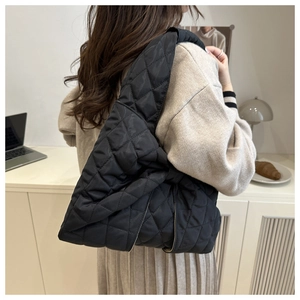 Detailed back view of a black quilted puffer tote bag with a soft padded texture