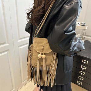 Bohemian suede crossbody bag with fringe tassels and wooden bead details in camel