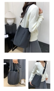 Detail view of black bucket bag with contrast white stitching and gold hardware