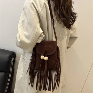 Brown suede crossbody bag with long tassels and wooden beads on a model back view