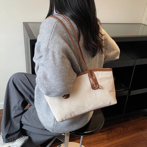 Retro cream tote bag with brown leather straps shown on shoulder in a lifestyle setting