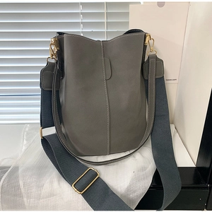 Deep grey leather bucket bag with wide woven strap and elegant gold metal hardware