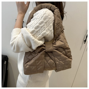 Close-up of quilted bow-knot shoulder bag in coffee brown with elegant stitched texture
