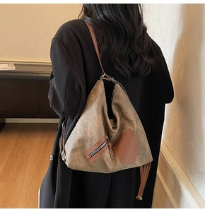 Close-up of vintage brown canvas hobo bag with zip pocket and premium leather strap details