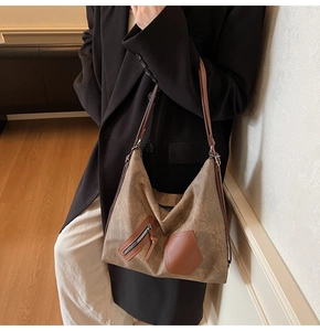 Macro detail of the vintage brown tote bag showing textured faux leather and metal zippers