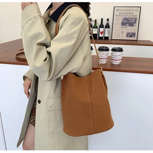 Detail of vintage brown bucket bag featuring contrast white stitching on matte leather