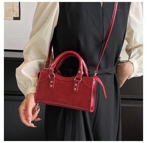 Detailed macro view of dark red matte leather texture with debossed logo on square bag
