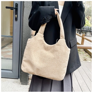 Primer plano del bolso tote de pana beige que muestra la textura de rayas verticales