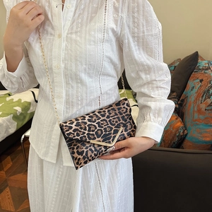 Women's leopard print envelope clutch bag with gold V-buckle and elegant chain strap