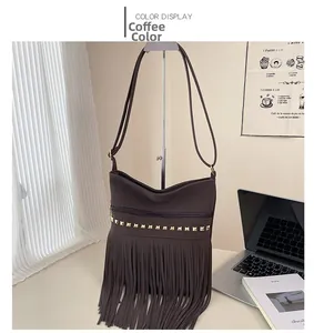 Dettaglio borsa a tracolla color caffè con rivetti dorati e lunghe nappe dinamiche