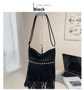Dettaglio borsa a tracolla nera con frange in pelle e borchie dorate piramidali