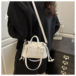 Close-up of white croc-embossed bucket bag with drawstring liner and fashion logo