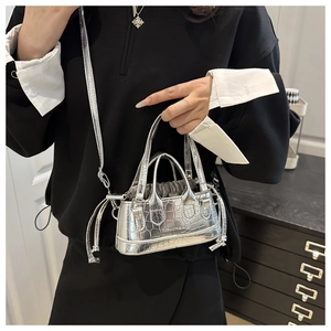 Dettaglio della mini borsa argento con trama a coccodrillo e coulisse interna funzionale