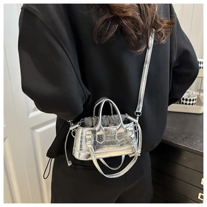 Détail du mini sac seau argenté à gaufrage crocodile avec doublure à cordon grise