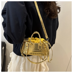 Detail of gold crocodile embossed mini bucket bag with yellow drawstring liner bag