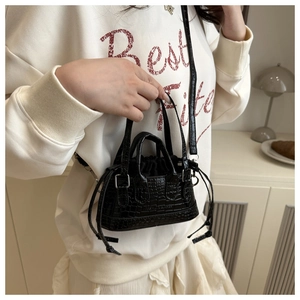 Detail of black crocodile texture mini Boston bag with drawstring and shoulder strap